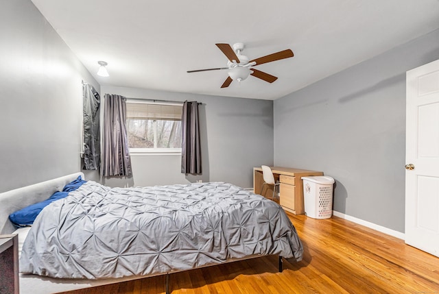 bedroom with wood finished floors, a ceiling fan, and baseboards