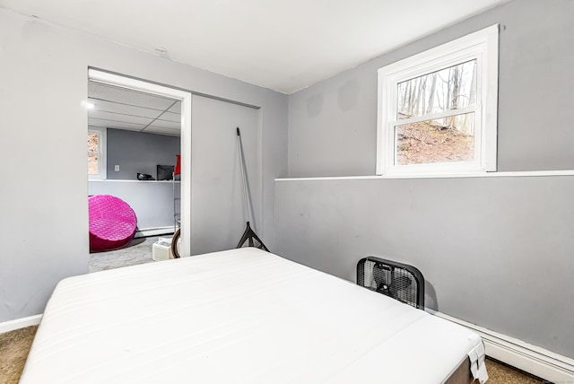 bedroom featuring a baseboard radiator, baseboards, and carpet flooring