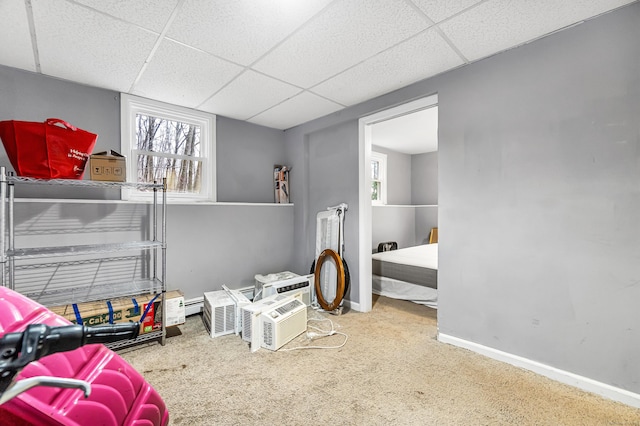 bedroom with a paneled ceiling, carpet flooring, baseboards, and baseboard heating