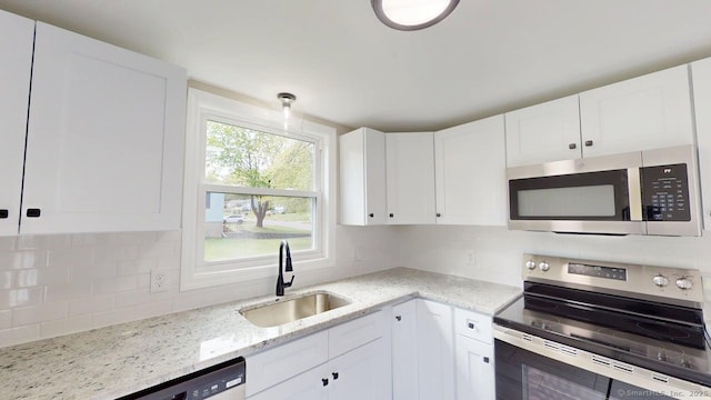 3 Richard Ln, Prospect, CT 06712 - kitchen featuring appliances with stainless steel finishes, a sink, backsplash, white cabinets, and light stone countertops