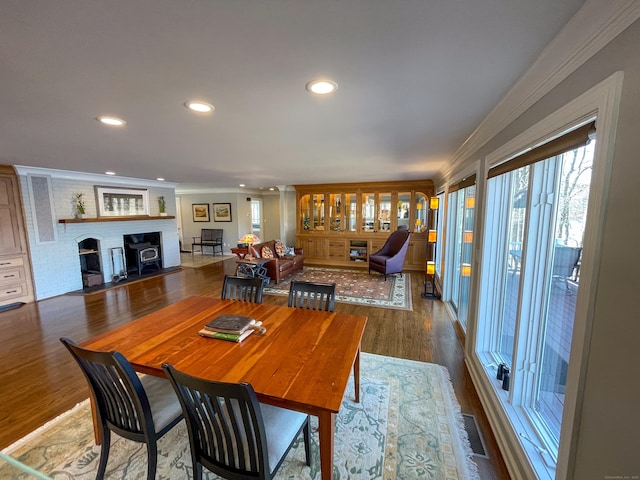 dining area with a wealth of natural light, visible vents, ornamental molding, and wood finished floors