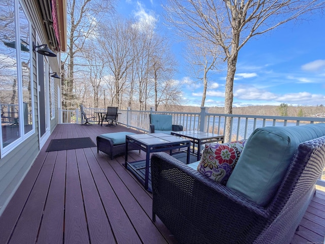 wooden terrace featuring a water view, outdoor dining area, and an outdoor hangout area