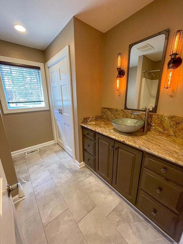 full bath featuring visible vents, baseboards, a shower, vanity, and marble finish floor
