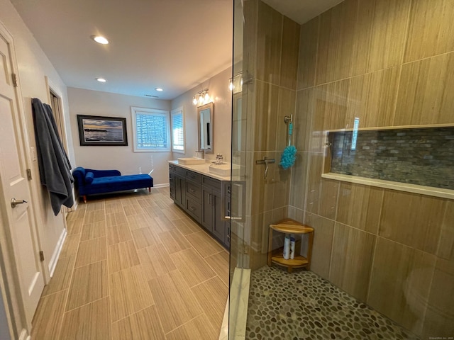 bathroom featuring a walk in shower, vanity, baseboards, and recessed lighting