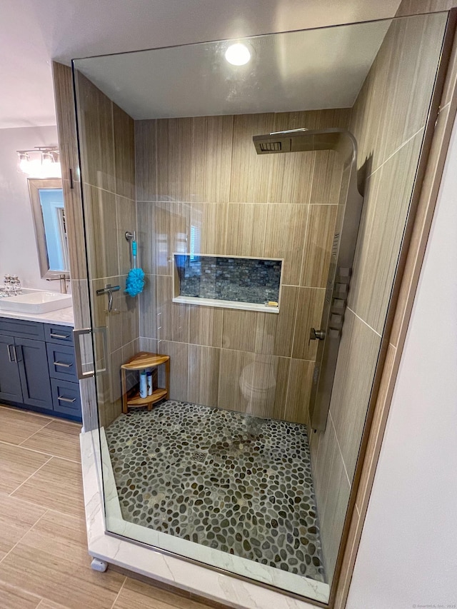 full bathroom featuring tile patterned floors, a stall shower, and vanity