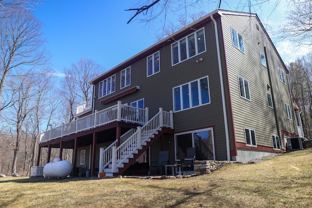 rear view of house with cooling unit, a yard, a wooden deck, and stairs