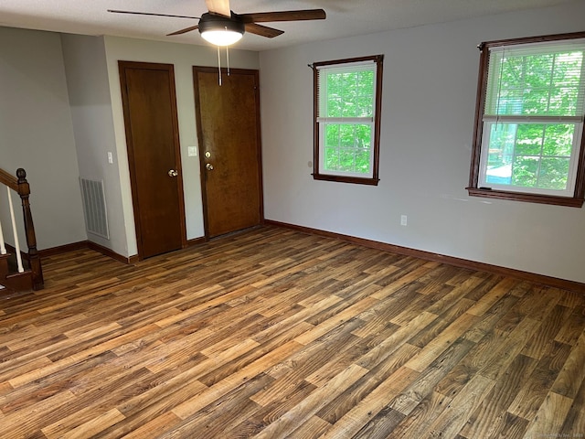 spare room featuring a ceiling fan, wood finished floors, and baseboards