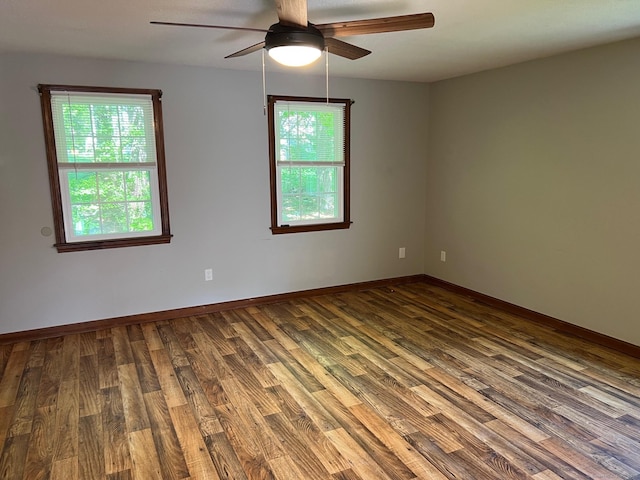unfurnished room featuring healthy amount of natural light, wood finished floors, and a ceiling fan
