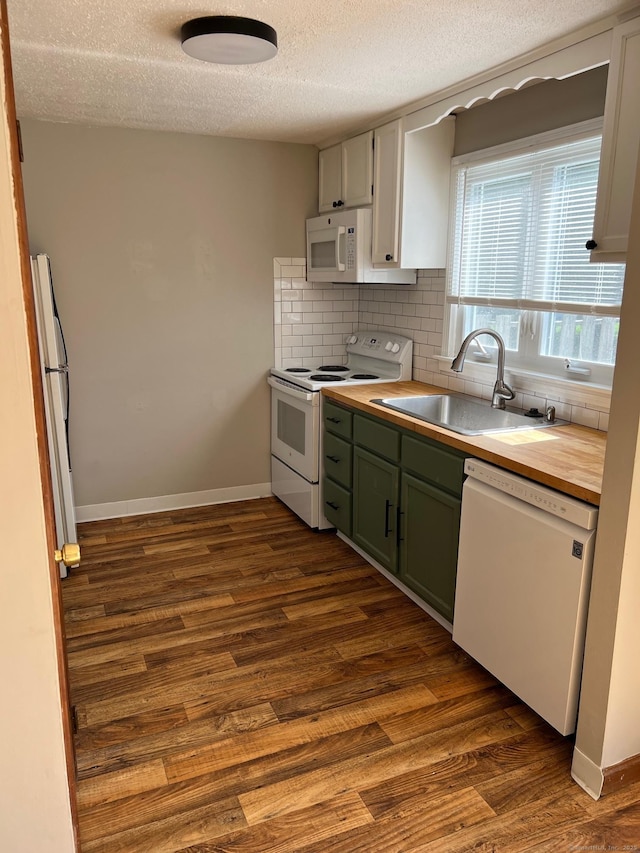 kitchen with white appliances, a sink, dark wood finished floors, a textured ceiling, and decorative backsplash
