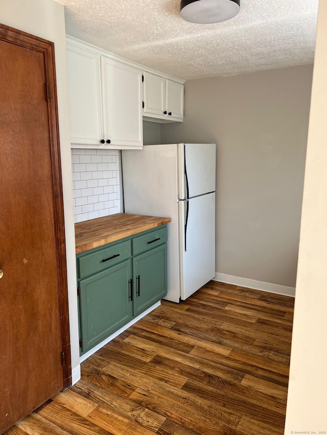 kitchen featuring butcher block countertops, a textured ceiling, green cabinetry, white cabinetry, and dark wood finished floors