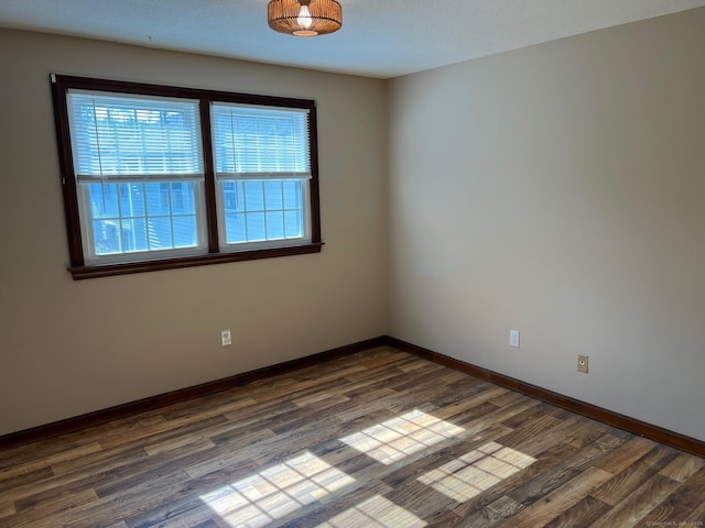 empty room with dark wood-style floors and baseboards