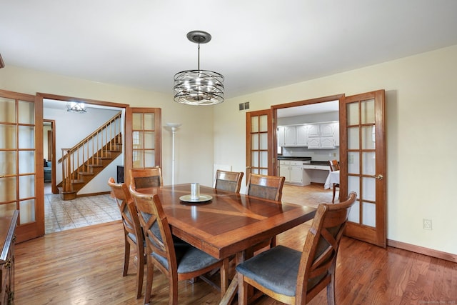 1069 Black Rock Tpke, Easton, CT 06612 - dining space with visible vents, an inviting chandelier, light wood-type flooring, stairway, and french doors