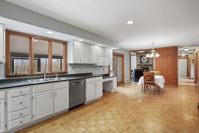 1069 Black Rock Tpke, Easton, CT 06612 - kitchen with stainless steel dishwasher, white cabinets, a sink, dark countertops, and a notable chandelier