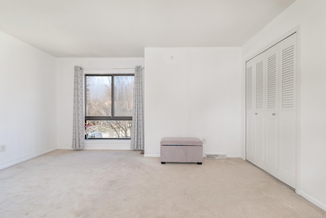 unfurnished bedroom featuring a closet, visible vents, baseboards, and carpet floors