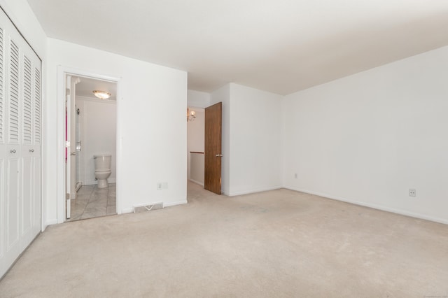unfurnished bedroom featuring light carpet, visible vents, baseboards, and a closet