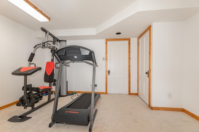 workout area with baseboards and carpet flooring