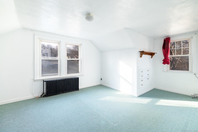 additional living space featuring radiator heating unit, carpet, vaulted ceiling, and baseboards