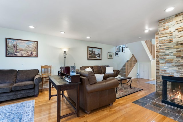 living area with baseboards, hardwood / wood-style flooring, a fireplace, recessed lighting, and stairway