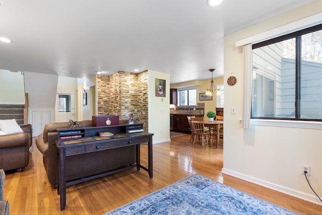 living room with wood finished floors, recessed lighting, baseboards, and stairs
