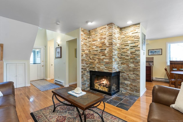 living room featuring baseboard heating, wood-type flooring, and baseboards