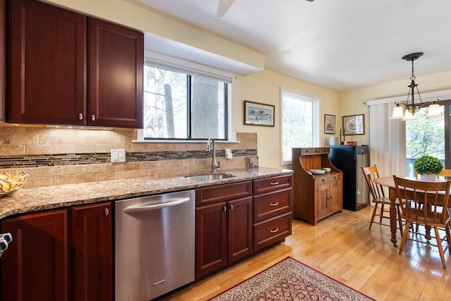 kitchen featuring dishwasher, a sink, light wood finished floors, backsplash, and light stone counters