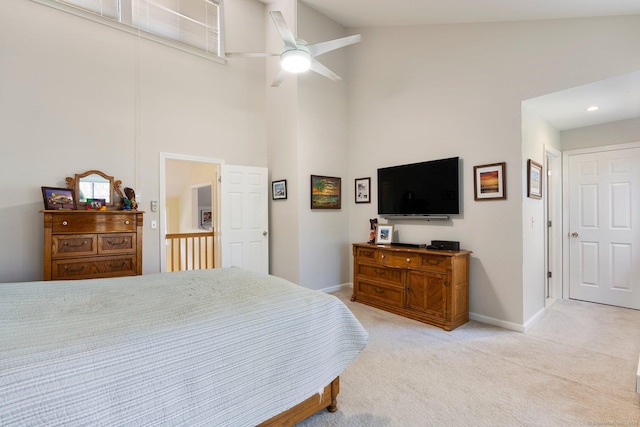 bedroom with a towering ceiling, light colored carpet, baseboards, and ceiling fan
