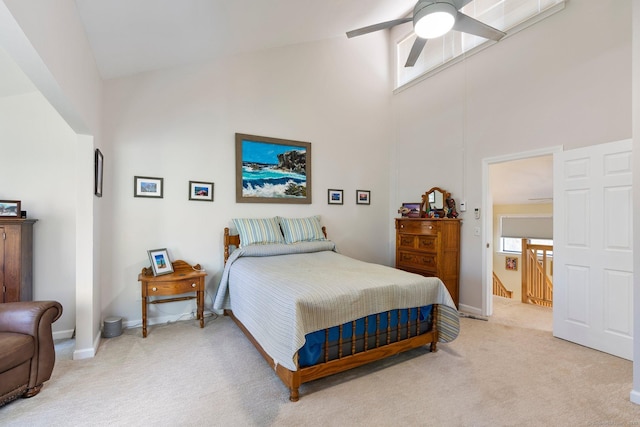 bedroom with high vaulted ceiling, light carpet, and baseboards
