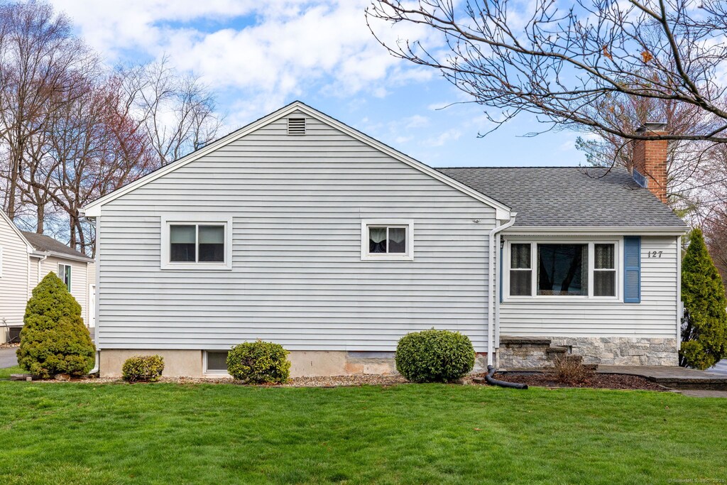 view of home's exterior featuring a shingled roof, a lawn, and a chimney