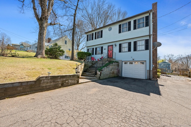 61 Harrington St, Meriden, CT 06451 - colonial home featuring aphalt driveway, a garage, a residential view, and a front lawn
