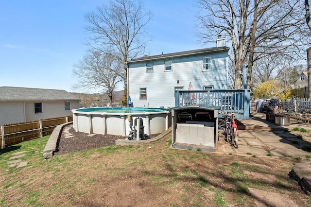 61 Harrington St, Meriden, CT 06451 - rear view of house with a deck, fence, a fenced in pool, and a chimney
