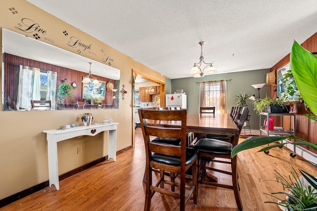 61 Harrington St, Meriden, CT 06451 - dining area with light wood-style floors, a notable chandelier, a textured ceiling, and a wealth of natural light