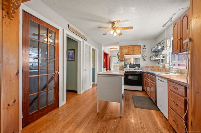 61 Harrington St, Meriden, CT 06451 - kitchen with dishwasher, a sink, brown cabinets, light wood-style flooring, and range
