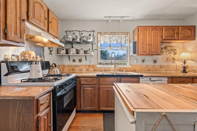 61 Harrington St, Meriden, CT 06451 - kitchen featuring black gas stove, wood counters, under cabinet range hood, white dishwasher, and a sink
