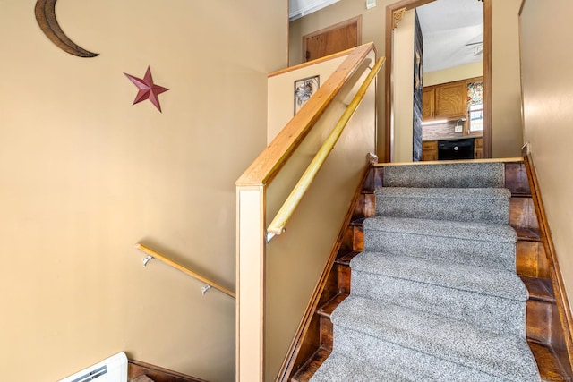 stairs featuring a baseboard heating unit