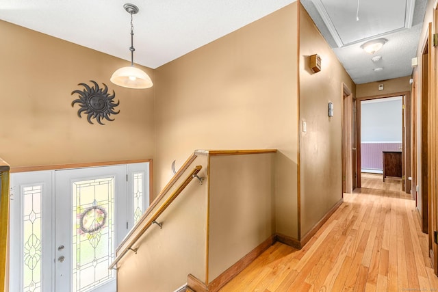 foyer entrance featuring light wood-style flooring, baseboards, and baseboard heating