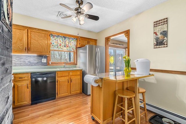 kitchen with dishwasher, a sink, a baseboard radiator, a kitchen breakfast bar, and light wood-style flooring