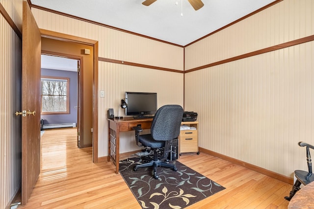 office with baseboards, a baseboard radiator, light wood-type flooring, a ceiling fan, and crown molding