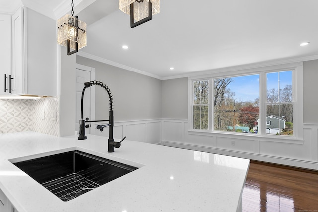 kitchen featuring a sink, ornamental molding, wainscoting, and recessed lighting
