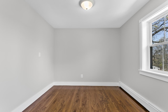 unfurnished room with dark wood-type flooring, a baseboard radiator, and baseboards