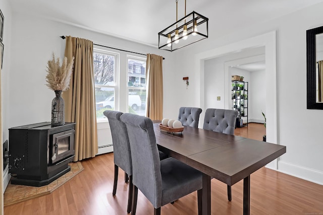 15 Smith St, Danbury, CT 06810 - dining area featuring an inviting chandelier, a wood stove, baseboards, a baseboard radiator, and light wood-style flooring