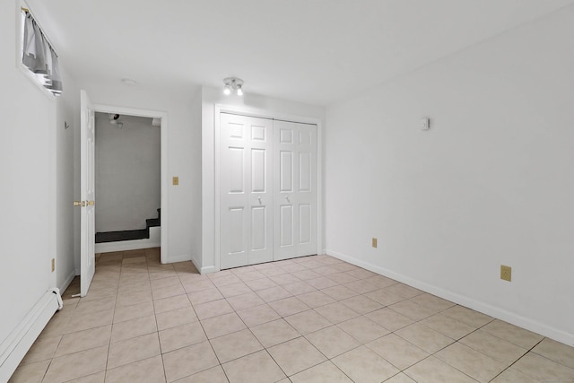 15 Smith St, Danbury, CT 06810 - unfurnished bedroom with a baseboard heating unit, light tile patterned floors, baseboards, and a closet