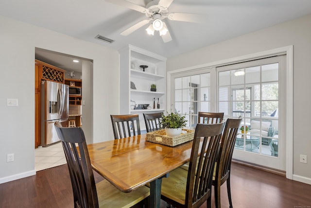 dining room featuring visible vents, baseboards, ceiling fan, and wood finished floors