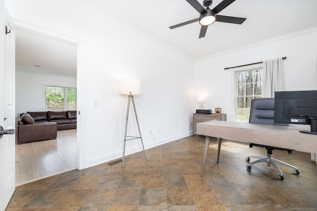 home office featuring crown molding, ceiling fan, stone finish floor, visible vents, and baseboards