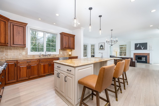 kitchen with light wood-style flooring, a kitchen bar, a sink, and decorative backsplash