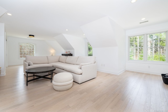 living room featuring plenty of natural light, visible vents, baseboards, and light wood-style flooring