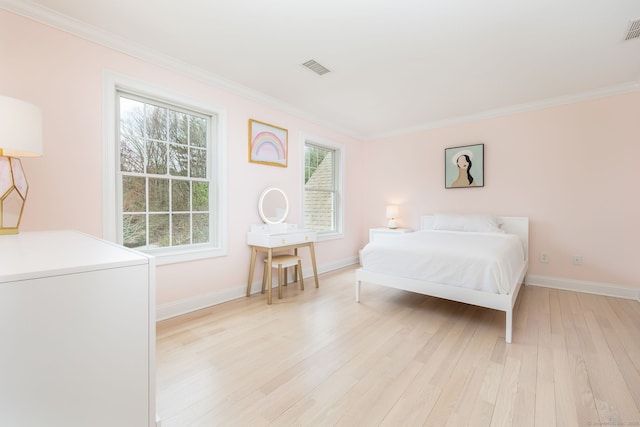 bedroom with light wood-style floors, baseboards, crown molding, and visible vents