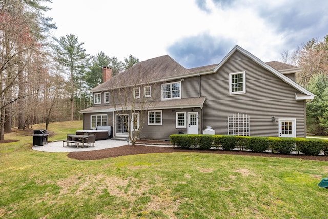 back of property featuring a patio area, a chimney, and a lawn