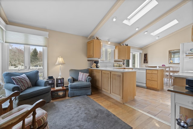 33 Cottage Ln, East Lyme, CT 06357 - kitchen with white dishwasher, light brown cabinets, vaulted ceiling with skylight, and open floor plan