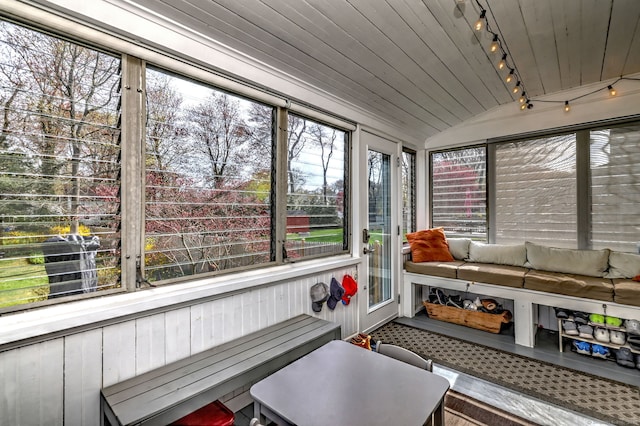 sunroom with track lighting and vaulted ceiling