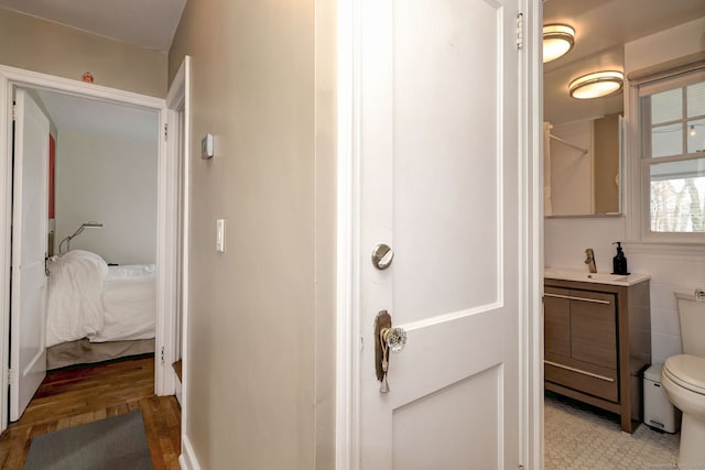 bathroom with ensuite bath, toilet, wood finished floors, and vanity